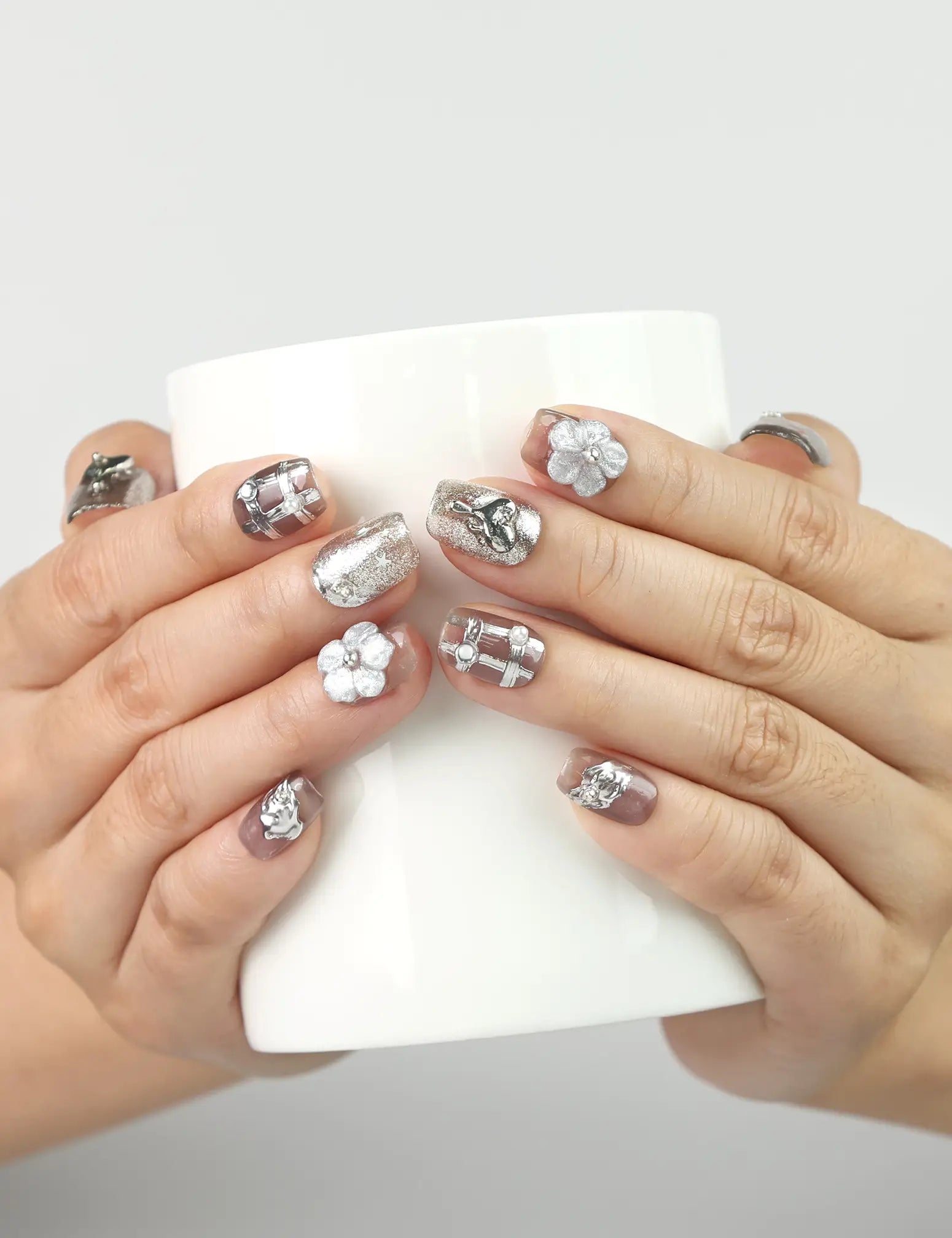 Nightfall metallic silver handmade Singapore press on nails with rhinestones, shown while holding a coffee cup, by naillover.