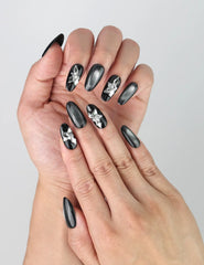 Close-up of Naillover’s handmade Singapore nails featuring glossy black base, shimmering silver tips, and delicate gem butterflies