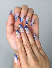 Close-up of Naillover’s handmade Singapore nails featuring flowing brushstroke art and delicate flower designs