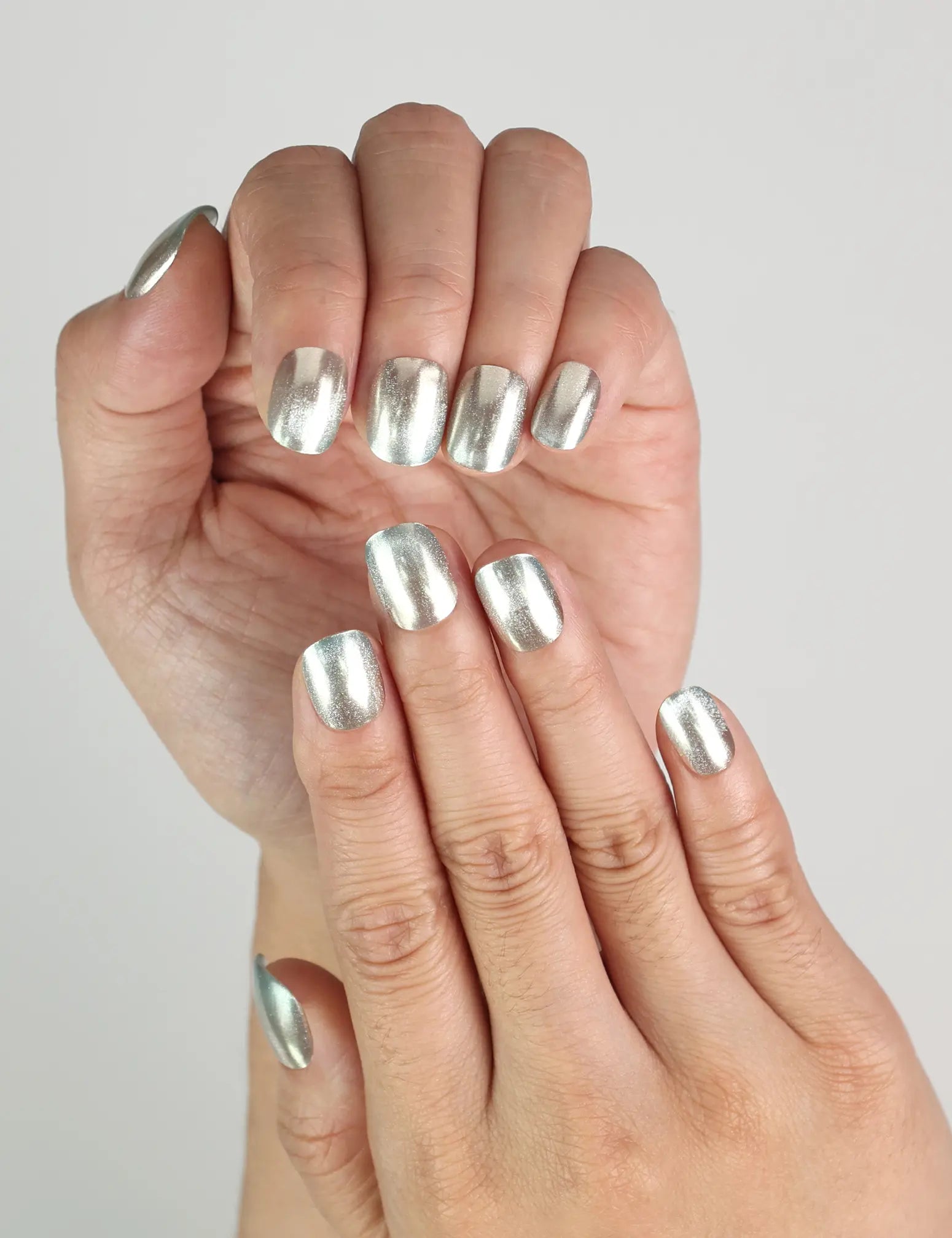 Hand model wearing Ocean Breeze handmade press on nails, cool blue shimmer design ideal for summer nails style.