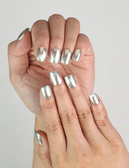 Hand model wearing Ocean Breeze handmade press on nails, cool blue shimmer design ideal for summer nails style.