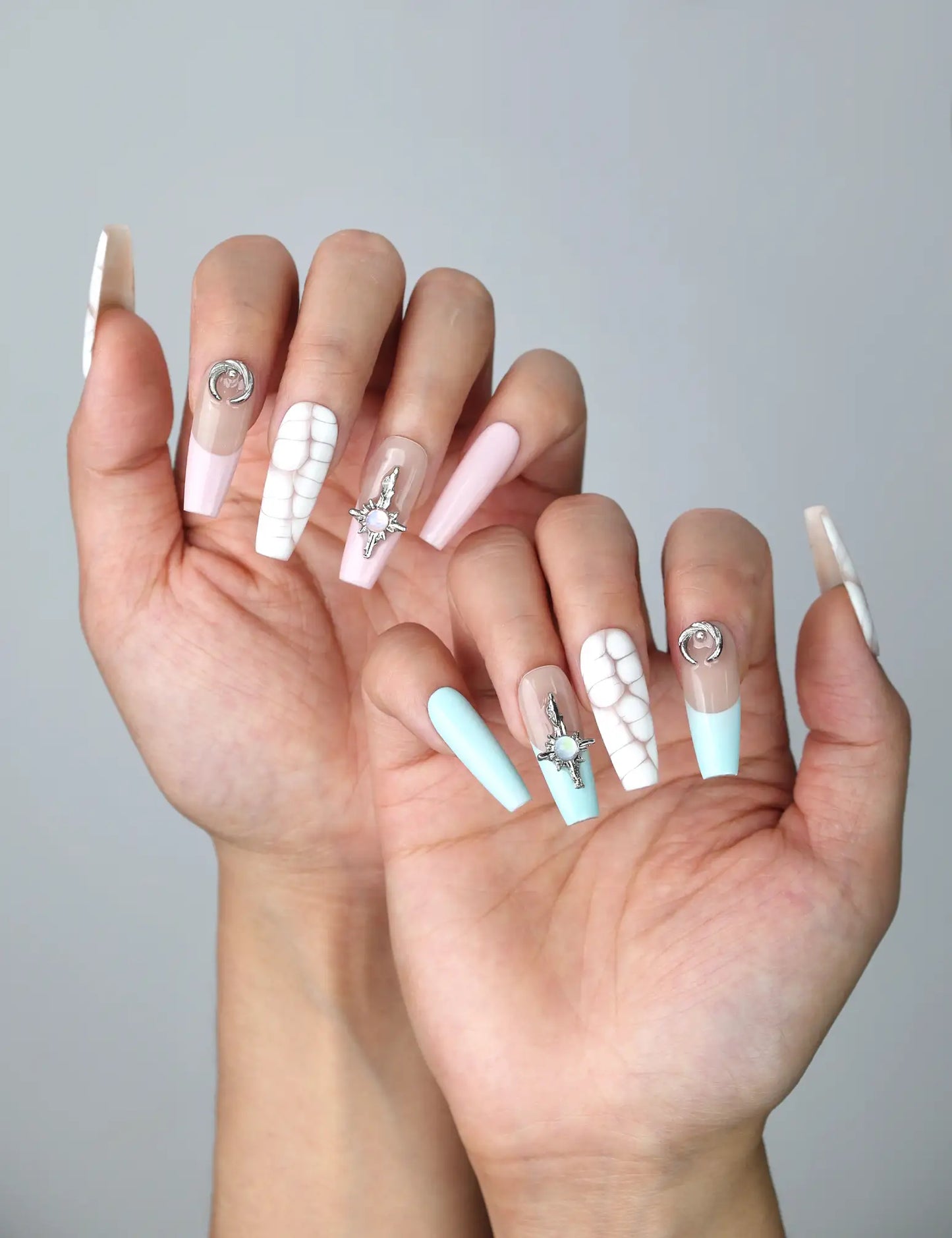 Side view of dreamy pastel coffin nails featuring cosmic accents, soft tones, and a cracked marble finish