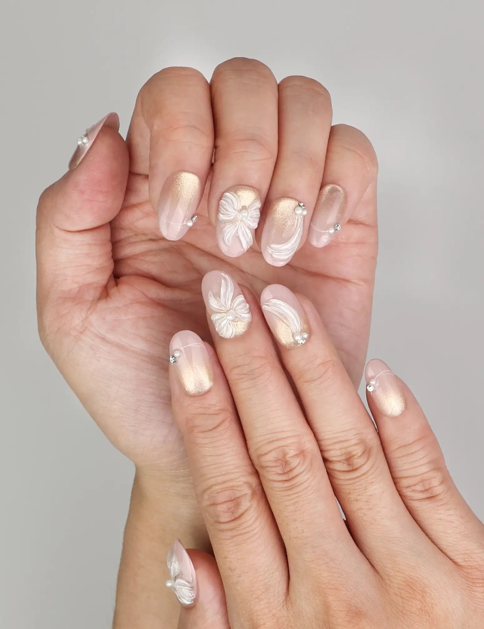 Close-up of Naillover Pearl Bloom Bronze Singapore press on nails showing floral shimmer finish with rhinestone embellishment.