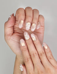 Close-up of Naillover Pearl Bloom Bronze Singapore press on nails showing floral shimmer finish with rhinestone embellishment.