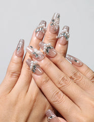 Close-up of Petal Crystal Singapore press on nails on hand, showing nude pink base with delicate petals and crystals by naillover