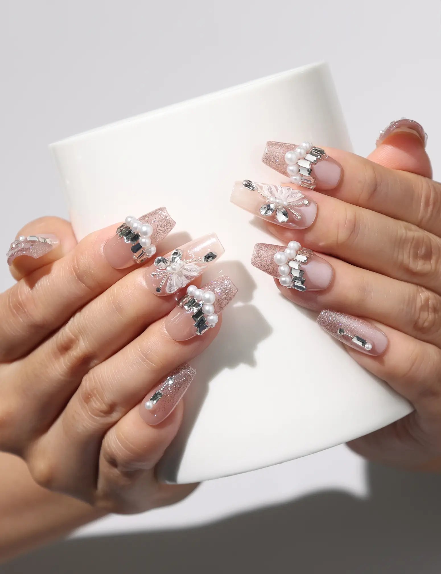 Petal Crystal handmade Singapore press on nails holding a coffee cup, showcasing delicate petals and shimmering crystals