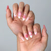 Side view of feminine almond nails with glossy base and dimensional flower embellishments in a romantic palette