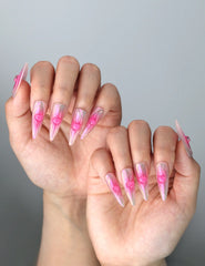 Side view of romantic pink press-on nails with iridescent shine and cute heart accents for a dreamy finish