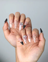 Side view of press-on nails with glossy pink-to-clear ombré and striking zebra patterns