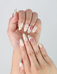 Close-up of Naillover’s handmade nails with sculpted multicolor flowers on a soft nude base