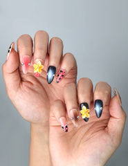 Side view of almond nails with neutral brown base, bold leopard detailing, and raised flower embellishments