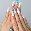 Hand model wearing blue almond-shaped press-on nails with raised seashell patterns and metallic starfish accents