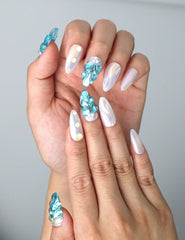 Close-up of Naillover’s handmade Singapore nails featuring pearlescent shell textures and golden sea star charms