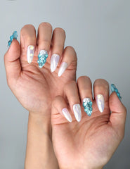 Side view of ocean-inspired almond nails with sculpted shell designs and luxe gold details