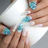 Hand holding a cup, showcasing Naillover’s sea-themed press-on nails with dimensional textures and gold marine embellishments