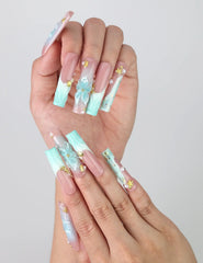 Fingers splayed to display intricate ocean-inspired long pipe nails with 3D flowers and metallic starfish by Naillover