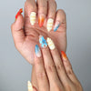 Close-up of Naillover’s handmade Singapore nails featuring vibrant red, blue, and yellow hues with 3D marine elements