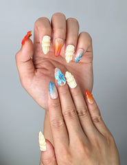 Close-up of Naillover’s handmade Singapore nails featuring vibrant red, blue, and yellow hues with 3D marine elements