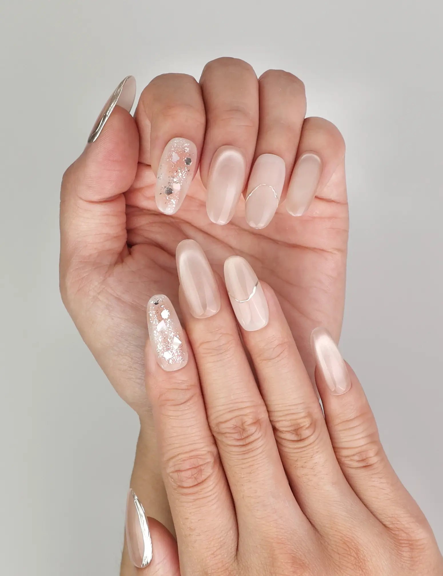Close-up of Naillover Shimmering Beige Singapore press on nails showing cat eye nails design with delicate golden details.