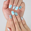 Close-up of Naillover’s short coffin nails in deep blue with reflective silver sheen and raised water drop designs