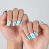 Side angle view of handmade Singapore blue coffin nails with chrome silver effects and liquid-style texture details