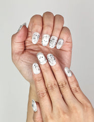 Close-up of Naillover Silver Starry Cutie Singapore press on nails featuring playful cartoon flower, shimmering stars, and black-white details.