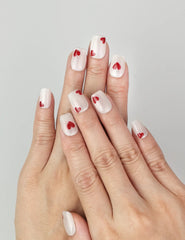 Model wearing naillover Sparkle Love Singapore press on nails, white glitter base with bold red hearts for a coquette cute nails style.