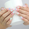 Hand holding a cup, displaying Naillover’s short pink coffin nails with sparkling base and colorful 3D sea star decor