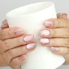 Starry Pink cat eye press on nails SG, handmade nails with shimmer and stars, holding a glass for lifestyle view
