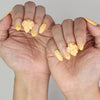 Naillover Sunny Bloom trendy nails styled on hand, featuring gradient yellow base with flower design.