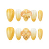 Flat lay of Naillover Sunny Bloom press on nails set, showcasing yellow-to-white gradient with 3D flower and pearl accent.