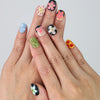 Hand showcasing squoval press on nails in black and nude with detailed 3D pink flower art by Naillover
