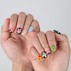 Elegant squoval nails with contrasting black and nude tones, highlighted by raised pink flower nail art