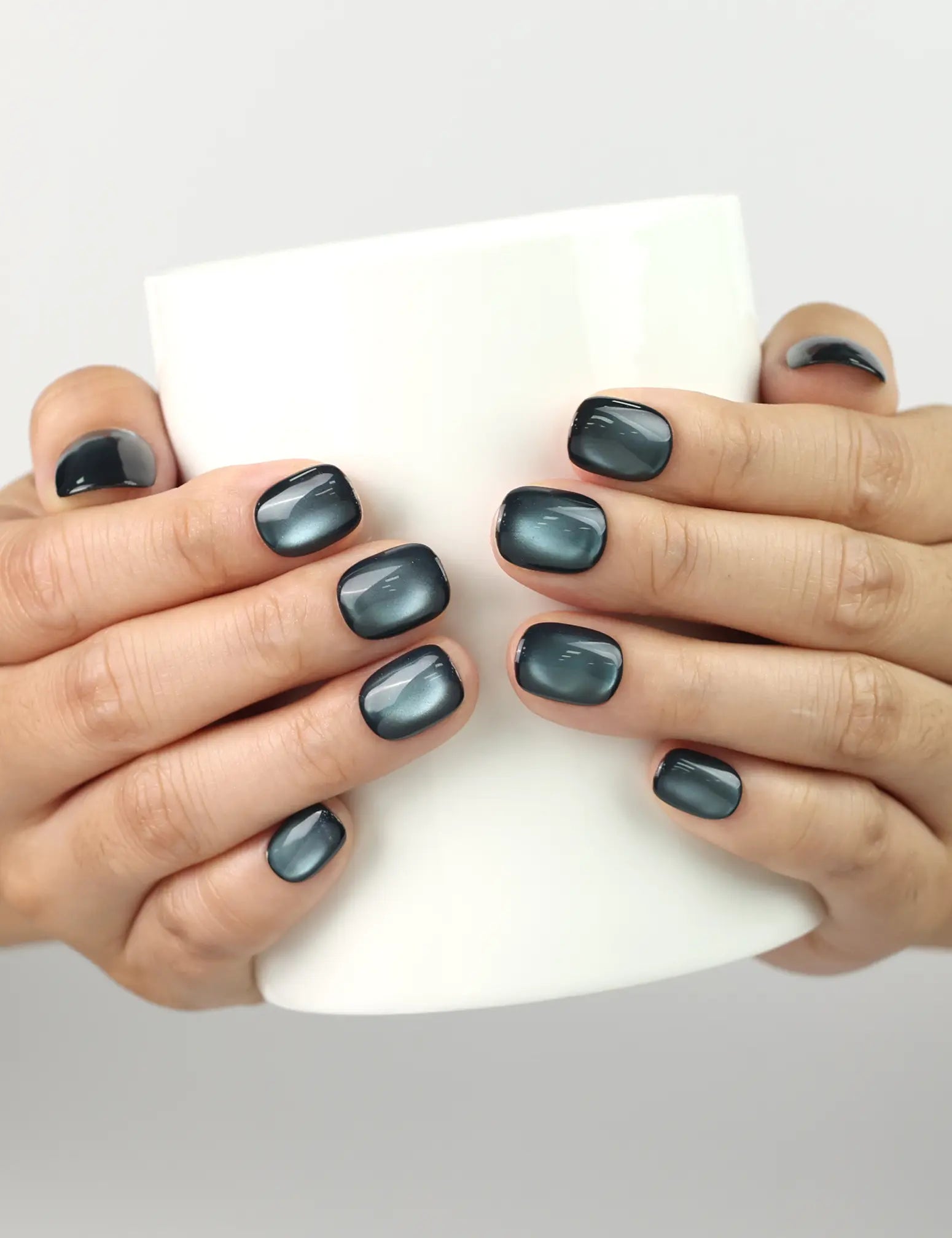 Hand holding a cup while wearing Teal Gleam handmade Singapore press on nails, teal iridescent glossy finish by naillover