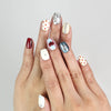 Hand wearing Vibrant Pop Singapore press-on nails with ivory base, red lips, silver buttons, and polka dots.