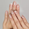 Hand wearing Naillover Whisper Beige handmade press on nails with sheer-to-nude gradient and silver gemstone accent.