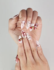 Close-up of Xmas Sparkle red and white press-on nails with bow accents, Singapore handmade nails by naillover