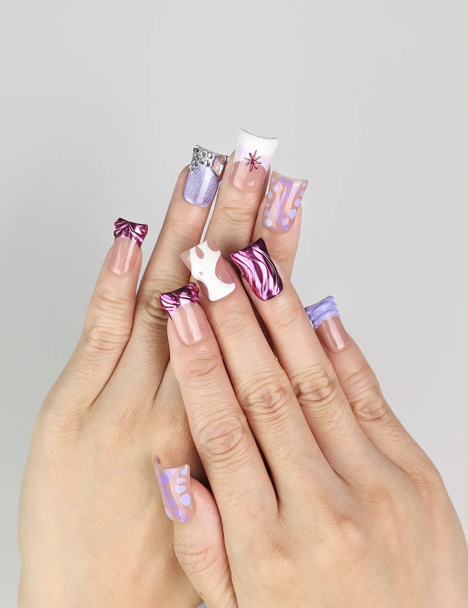 Hand wearing Y2K Purple Haze handmade Singapore press on nails by naillover, showing vibrant purple hues and linear designs.